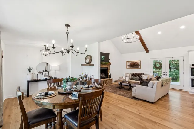 a view of a dining room with furniture a chandelier and wooden floor