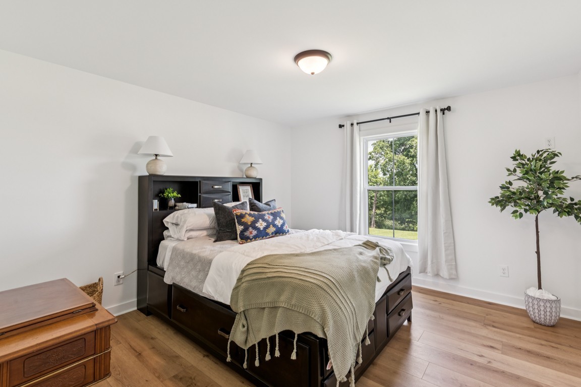 2590 Oakdale Road Westmoreland, TN 37186 - Photo 21 of 25 a bedroom with a bed and a potted plant