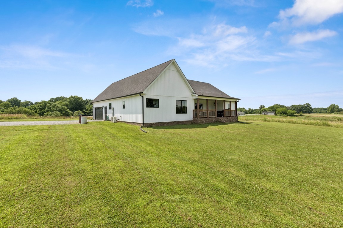 2590 Oakdale Road Westmoreland, TN 37186 - Photo 3 of 25 a front view of a house with a garden and lake view
