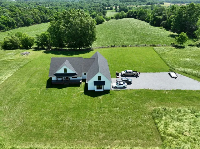 a car parked in the grass near a house