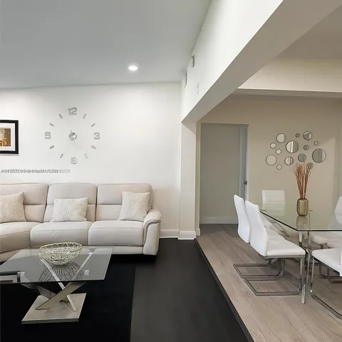 a living room with furniture a rug and a table