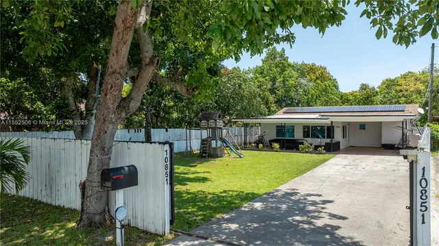 a view of a house with backyard and sitting area