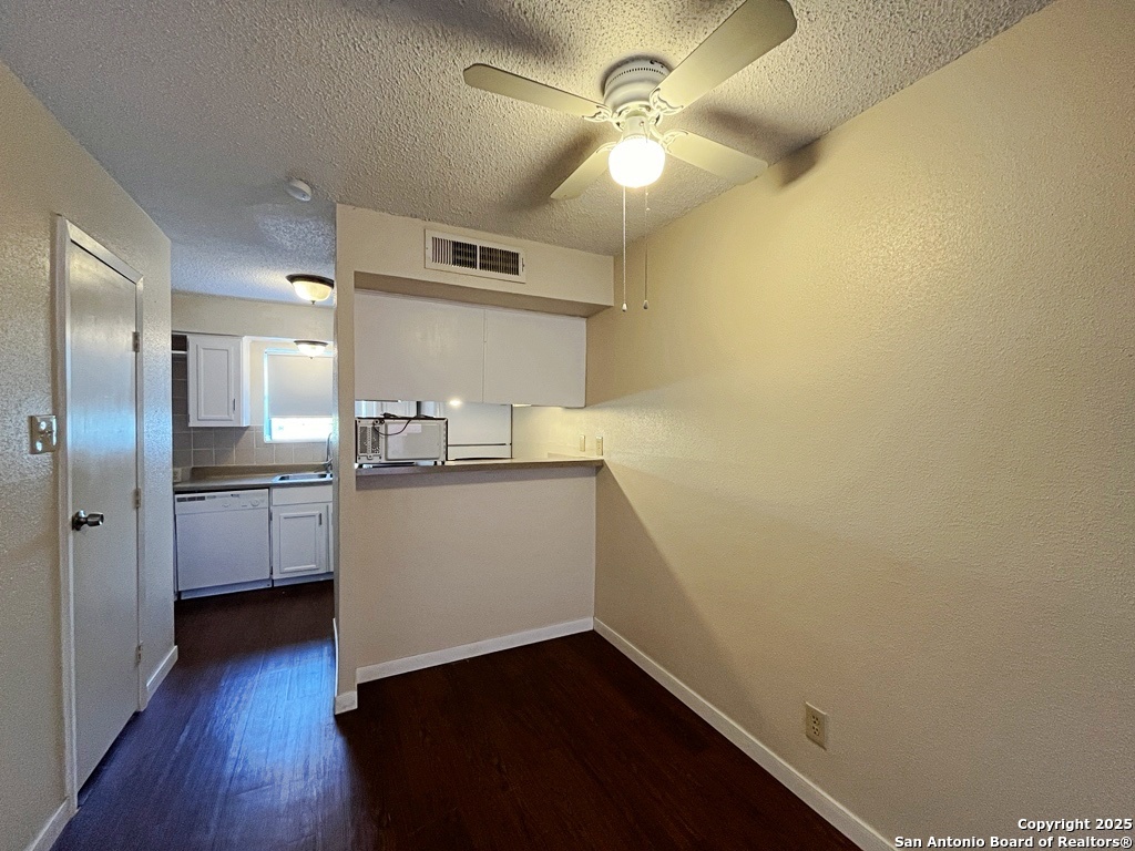 3243 Nacogdoches Road, Unit 404 San Antonio, TX 78217 - Photo 10 of 30 a view of a kitchen with a sink a refrigerator a ceiling fan and wooden floor