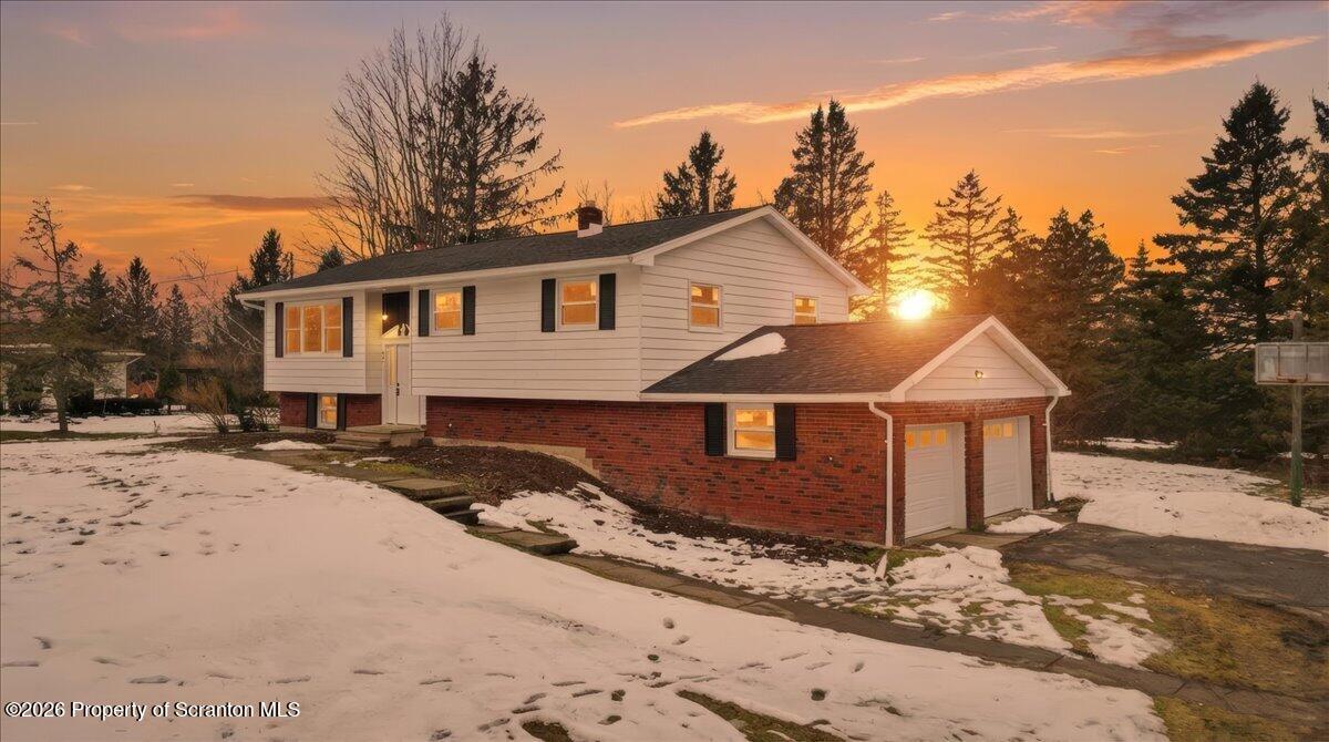 a front view of a house with a yard covered in snow