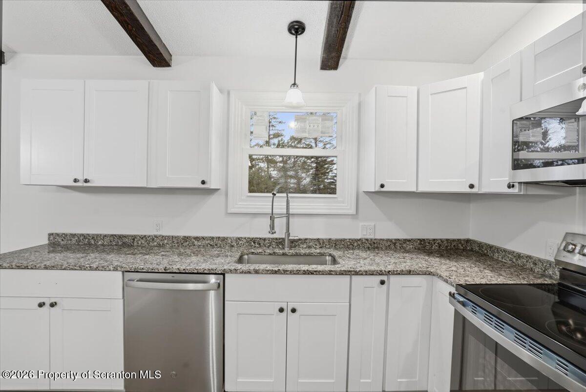 847 Griffin Pond Road Clarks Summit, PA 18411 - Photo 19 of 57 a kitchen with granite countertop white cabinets and a sink