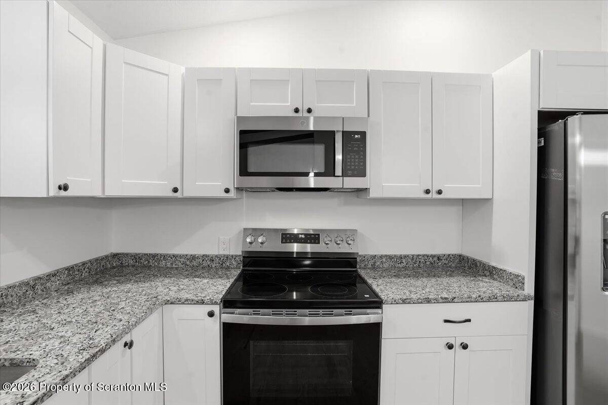 847 Griffin Pond Road Clarks Summit, PA 18411 - Photo 20 of 57 a kitchen with granite countertop white cabinets and stainless steel appliances