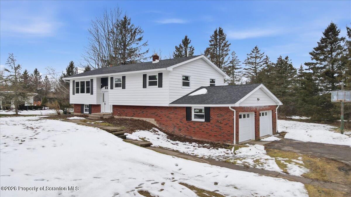 847 Griffin Pond Road Clarks Summit, PA 18411 - Photo 4 of 57 a front view of a house with a yard covered with snow