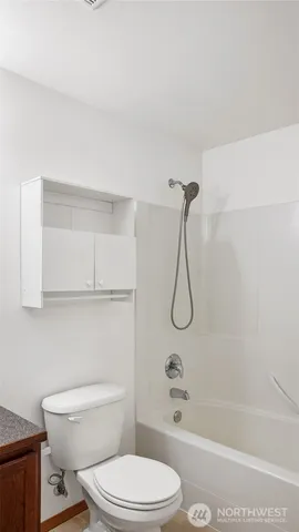 a bathroom with a granite countertop toilet and a shower