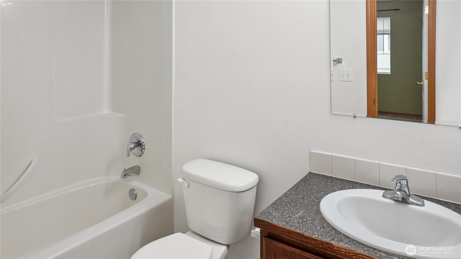 940 Capstone Avenue Othello, WA 99344 - Photo 18 of 25 a bathroom with a granite countertop sink a toilet and bathtub