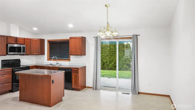 a view of a kitchen with stainless steel appliances granite countertop a stove and a sink