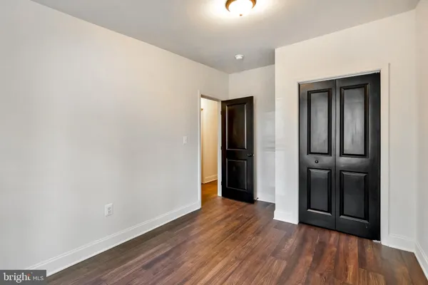 a view of an empty room with closet and a window