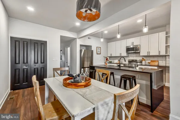 a kitchen with a dining table chairs and a refrigerator