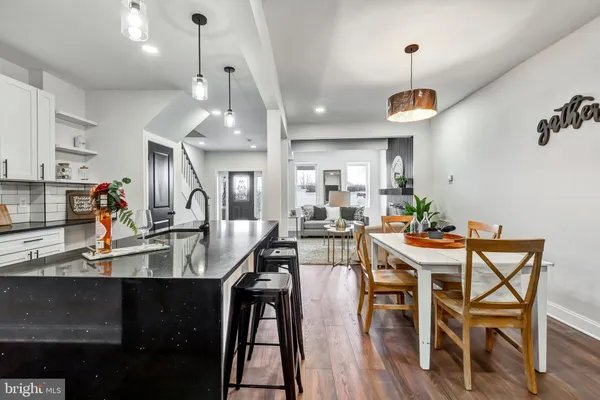 a view of a dining room and livingroom with furniture wooden floor a chandelier