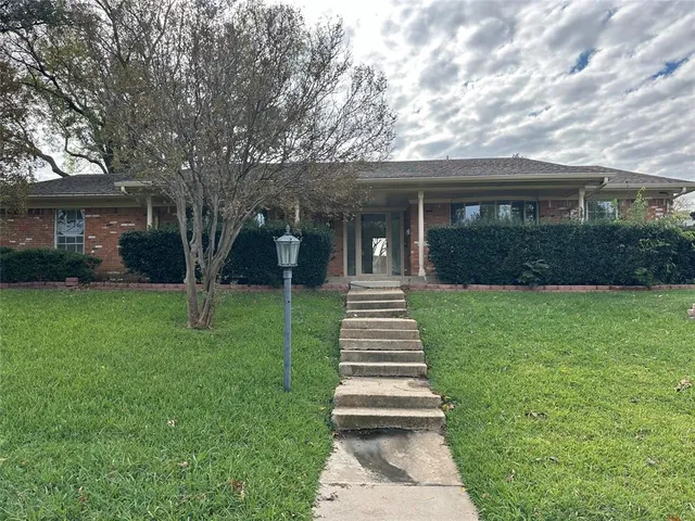 a front view of a house with a yard and green space