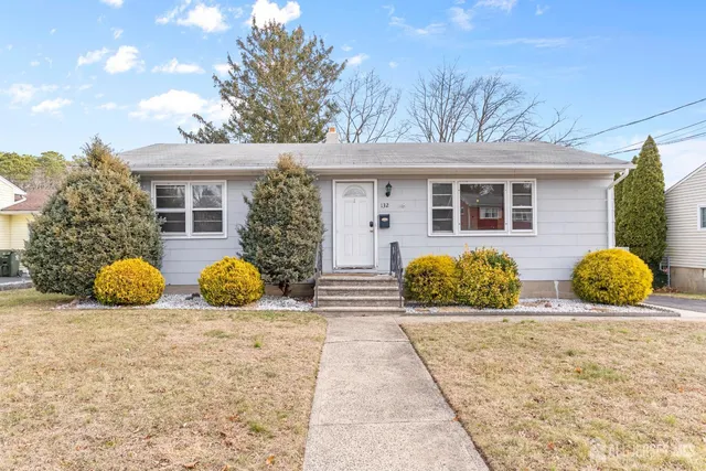 a view of a brick house with large windows and a large tree