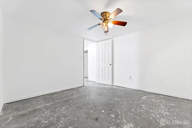 an empty room with a window and a fan