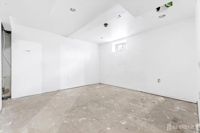 an empty room with a ceiling fan and window