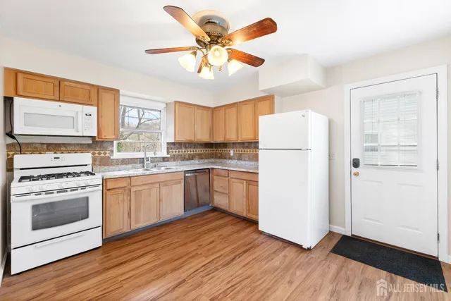 a kitchen with granite countertop white cabinets and white appliances