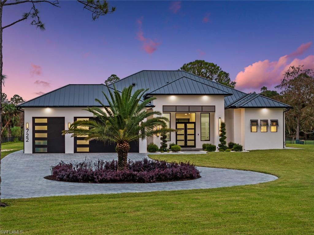 722 19th Street Southwest Naples, FL 34117 - Photo 1 of 47 View of front facade with a garage and a yard