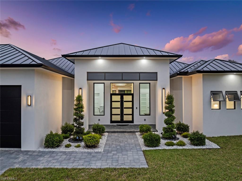 722 19th Street Southwest Naples, FL 34117 - Photo 2 of 47 Exterior entry at dusk with a yard