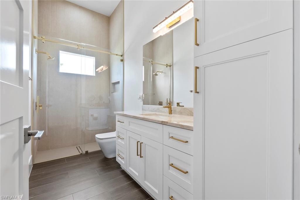 722 19th Street Southwest Naples, FL 34117 - Photo 33 of 47 Bathroom featuring vanity, tiled shower, and toilet