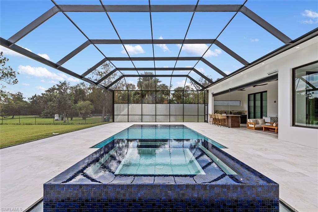 722 19th Street Southwest Naples, FL 34117 - Photo 46 of 47 View of swimming pool with a lanai, a patio, a bar, an outdoor hangout area, and an in ground hot tub