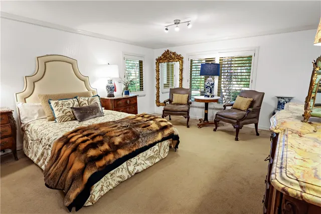 a bedroom with a bed flat screen tv and a large window