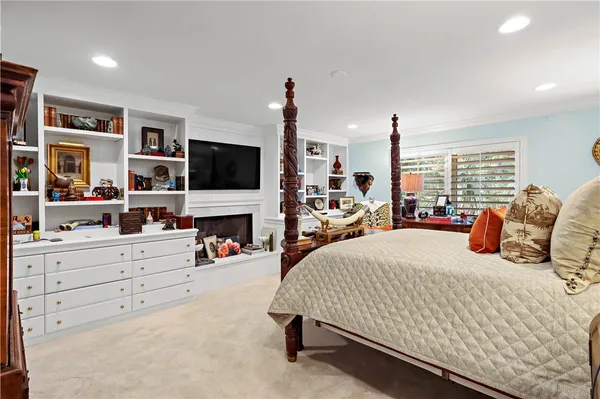 a bedroom with a bed flat screen tv and a large window