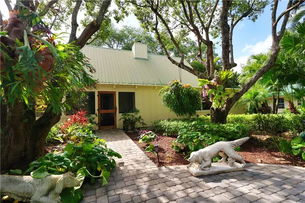 a front view of a house with lots of potted plants