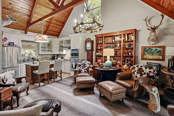 a living room with patio furniture and a chandelier
