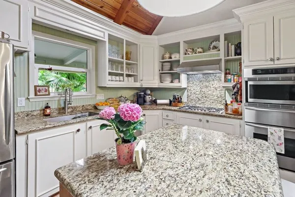 a kitchen with stainless steel appliances kitchen island granite countertop a stove a sink and a microwave