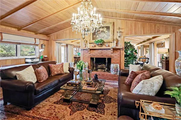 a living room with furniture chandelier and a fireplace
