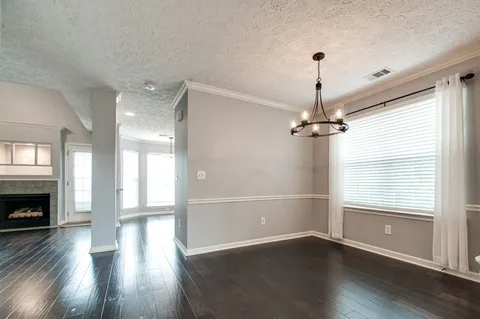 a view of empty room with wooden floor fireplace and windows