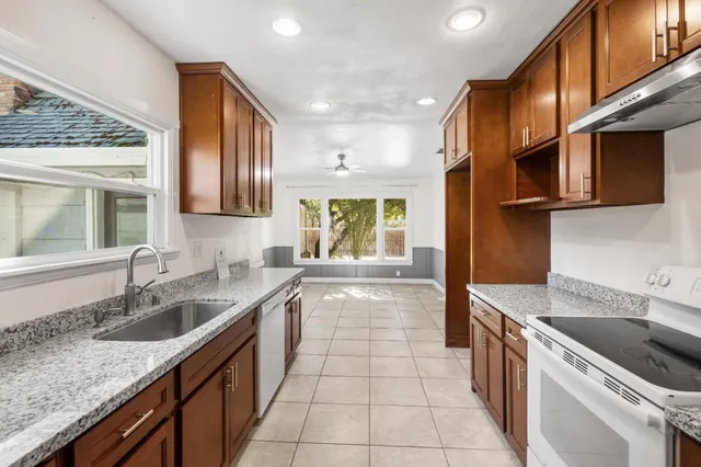 a kitchen with granite countertop a sink and a stove