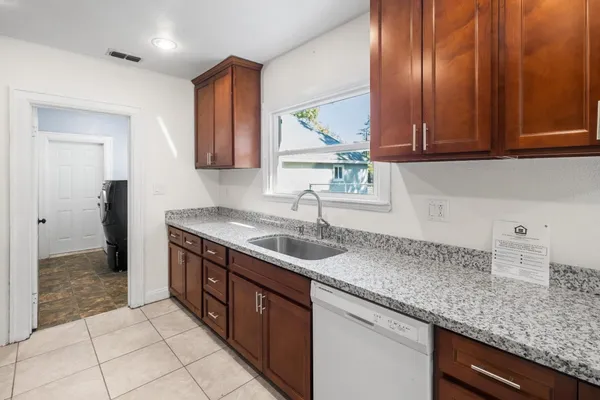 a kitchen with granite countertop a sink and a window