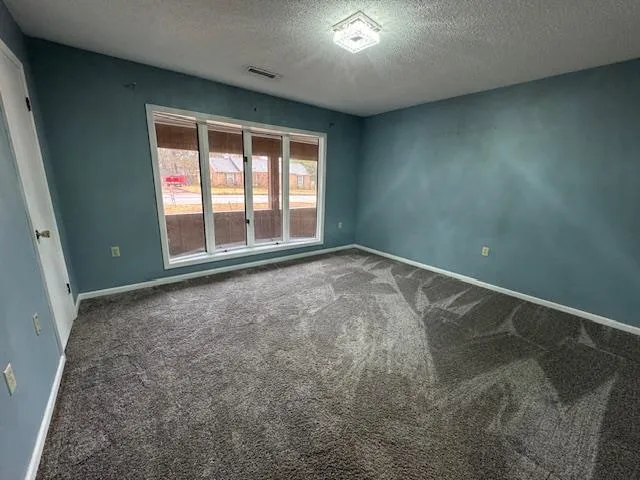 an empty room with floor to ceiling windows and chandelier