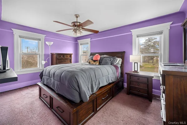 a bedroom with a bed and a dresser next to a window