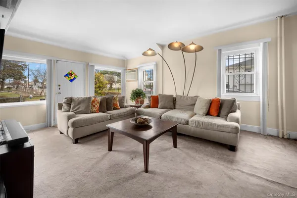 a living room with furniture a window and a flat screen tv