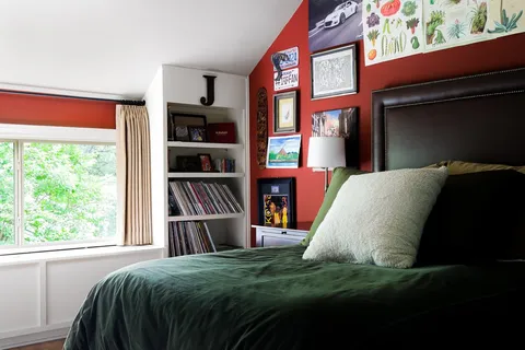 a bed sitting in a bedroom next to a window
