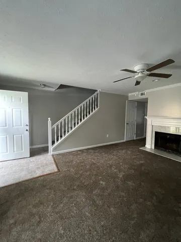 a view of an empty room with a fireplace and a window