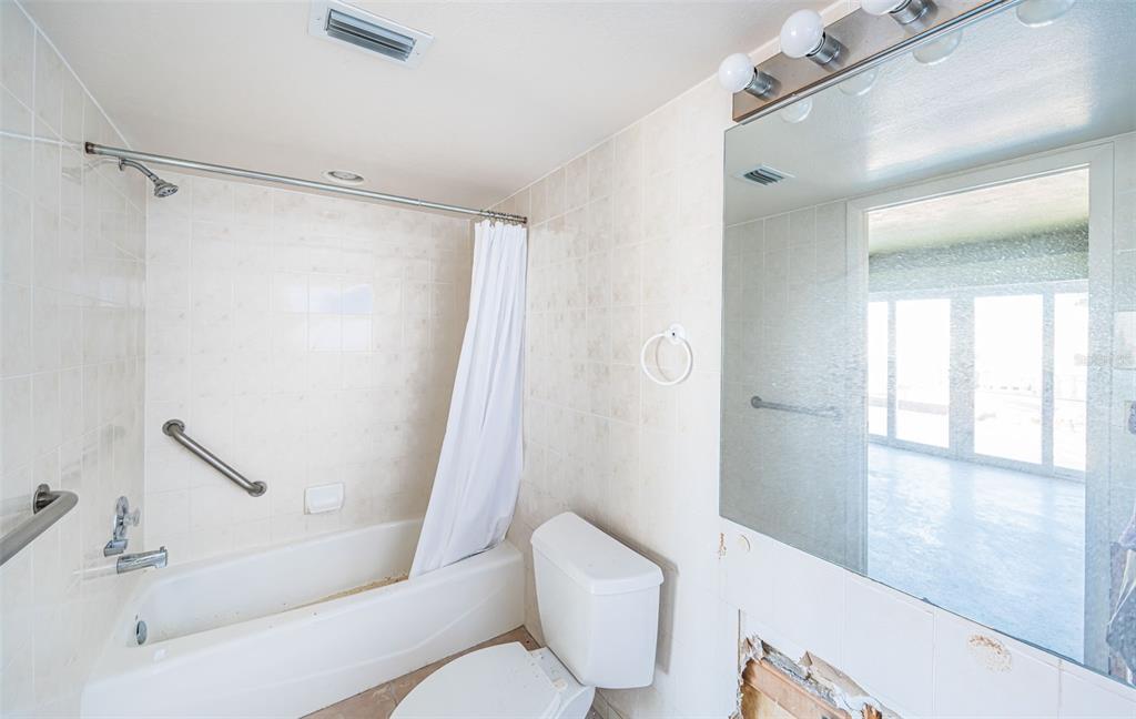 30 Dolphin Drive Treasure Island, FL 33706 - Photo 26 of 71 a white toilet sitting next to a bathroom sink