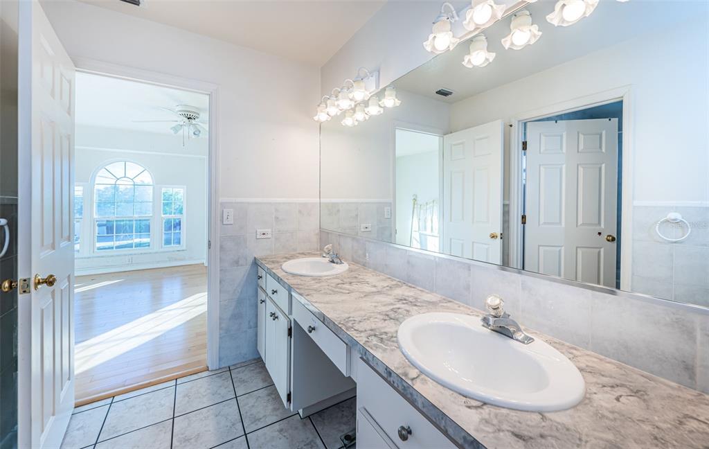 30 Dolphin Drive Treasure Island, FL 33706 - Photo 41 of 71 a bathroom with a granite countertop sink a large mirror and a shower