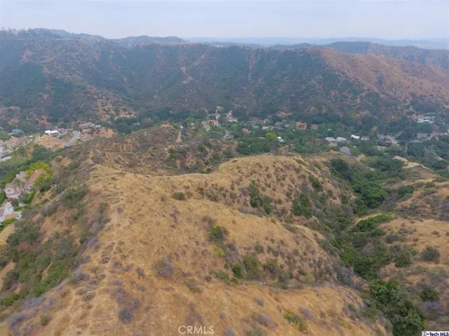 a view of a dry yard with mountains in the background