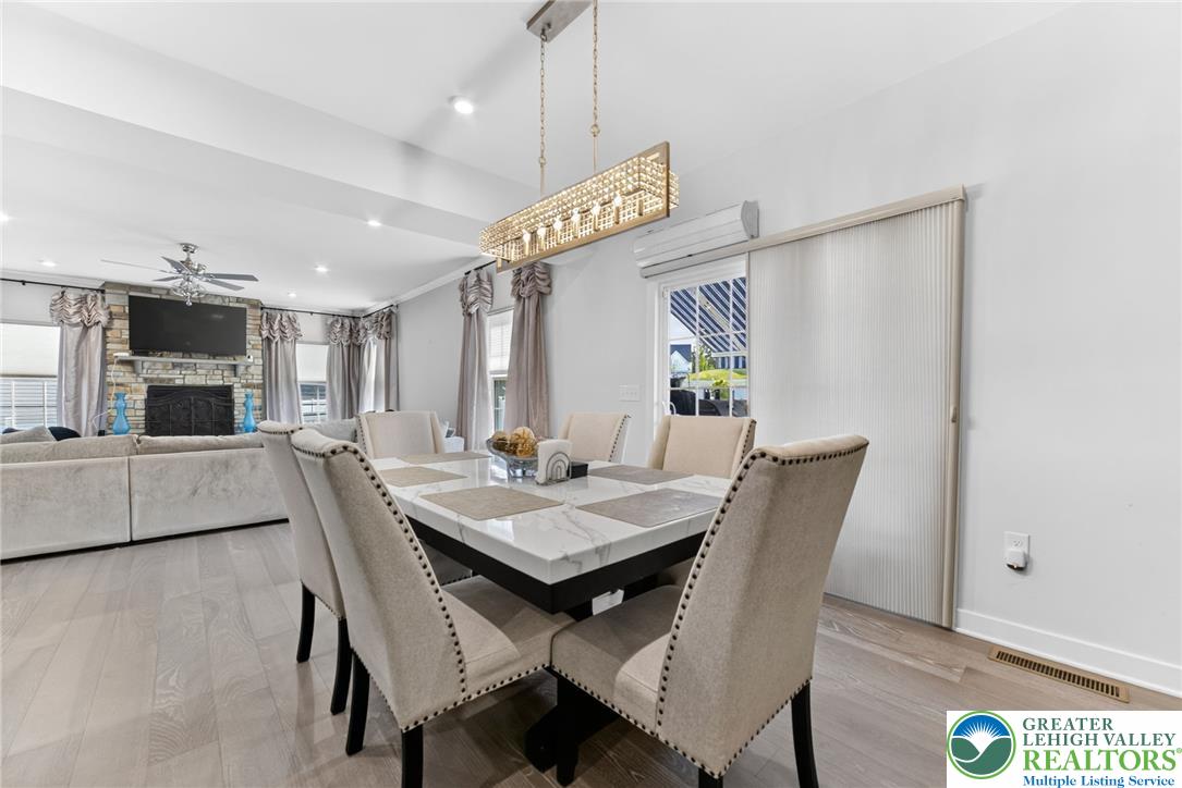 3952 Orth Street Bethlehem, PA 18020 - Photo 13 of 60 An open-concept living space highlights a dining area with a modern chandelier and light-toned hardwood flooring.