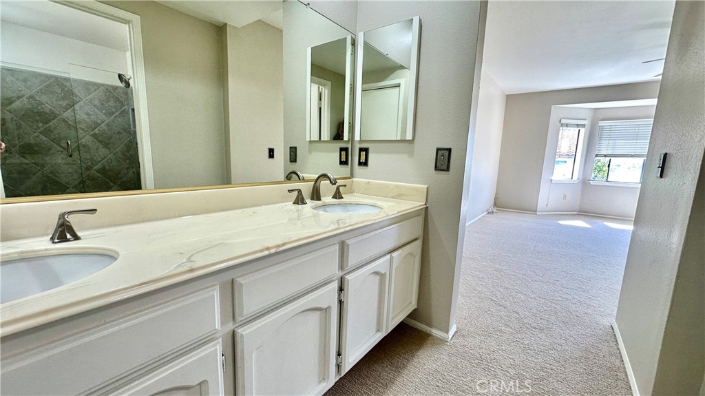 19526 Turtle Ridge Lane Porter Ranch, CA 91326 - Photo 15 of 27 a bathroom with a double vanity sink and a mirror