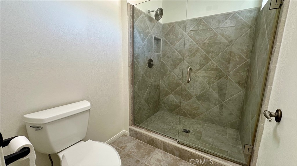 19526 Turtle Ridge Lane Porter Ranch, CA 91326 - Photo 16 of 27 a white toilet next to a bathroom shower