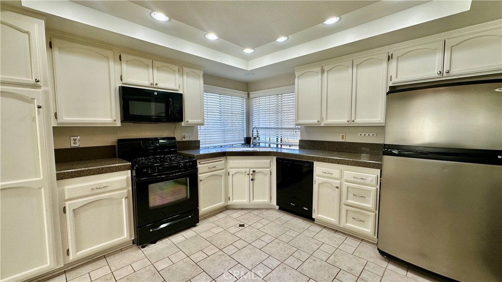 19526 Turtle Ridge Lane Porter Ranch, CA 91326 - Photo 10 of 27 a kitchen with granite countertop a sink a stove top oven and cabinetry
