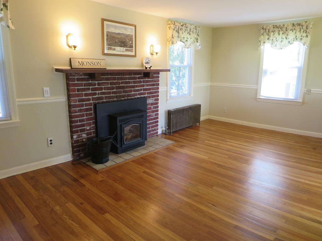 117 Stebbins Road Monson, MA 01057 - Photo 9 of 27 a view of an empty room with wooden floor fireplace and a window
