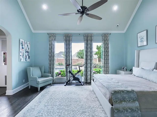 a spacious bedroom with a bed a couch and a large window