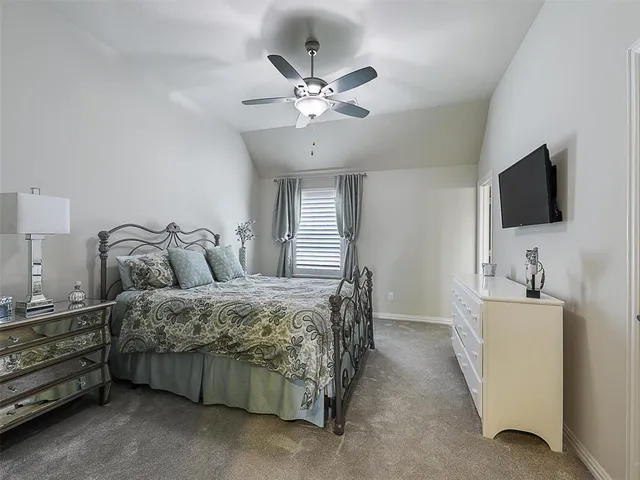 a spacious bedroom with a bed and a flat screen tv